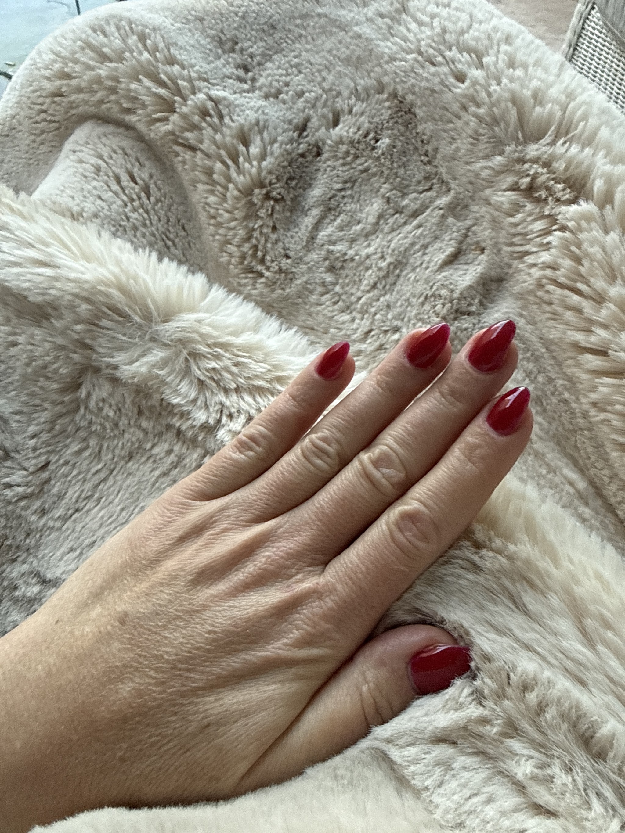 Donkerrode nagels op een bontdeken