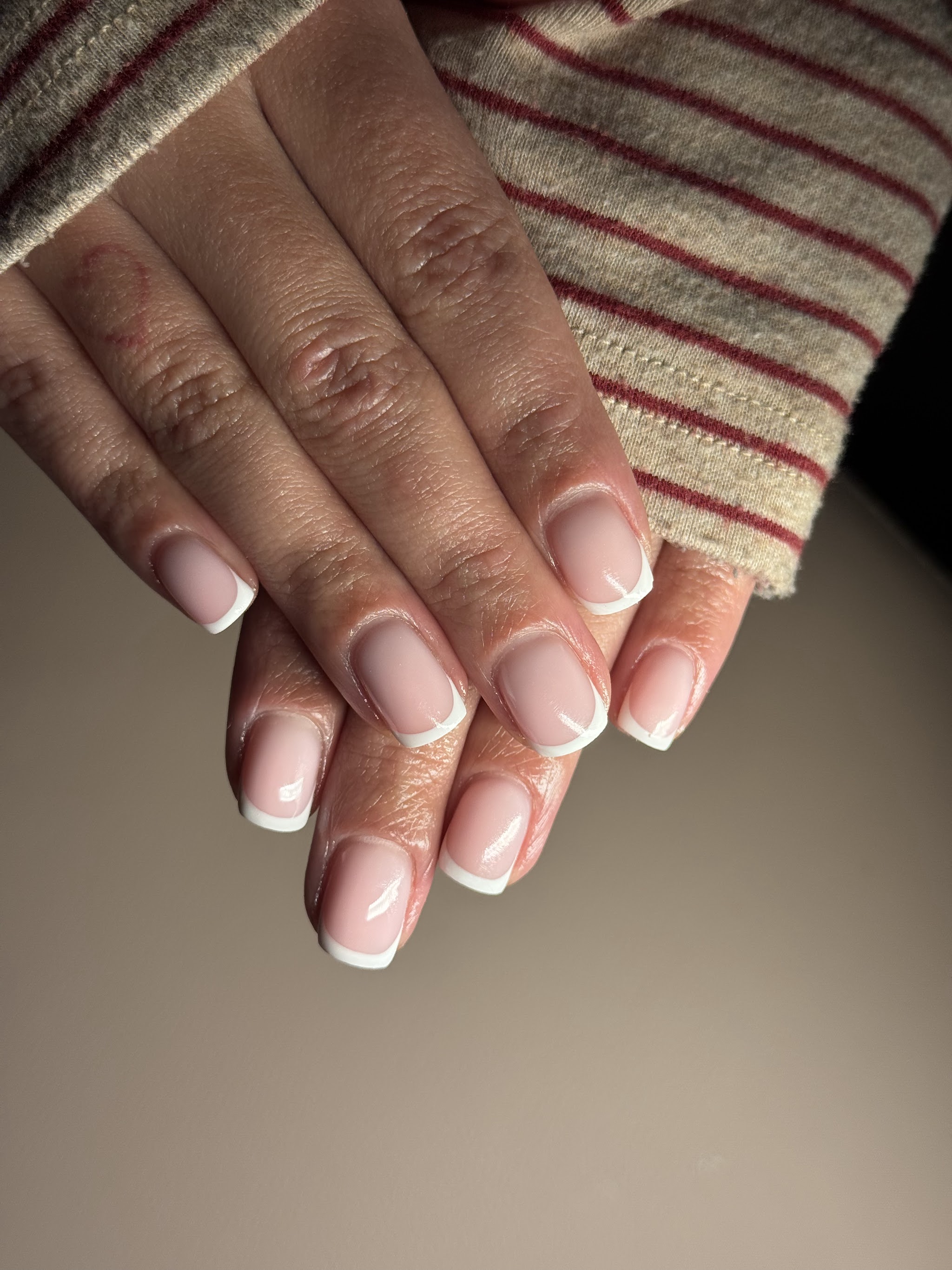 BIAB French nagels naast een gestreepte mouw